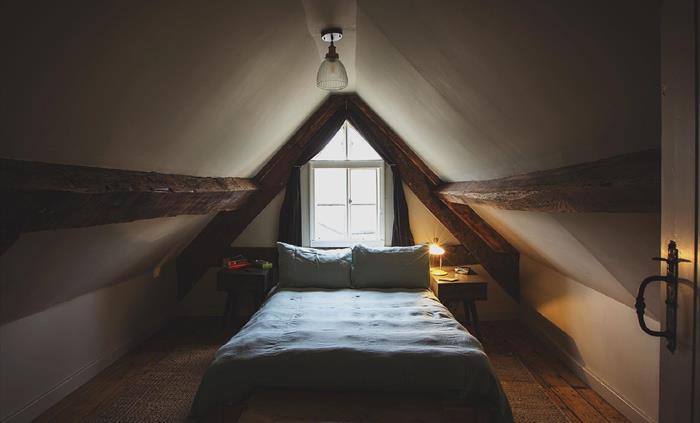 The second bedroom can be found in the eaves of the house.